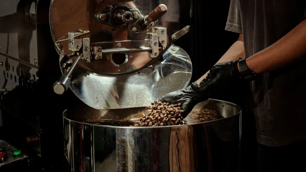 Coffee Indonesia beans being released from a roasting machine at Bali Origins, highlighting controlled roasting and consistent quality standards.