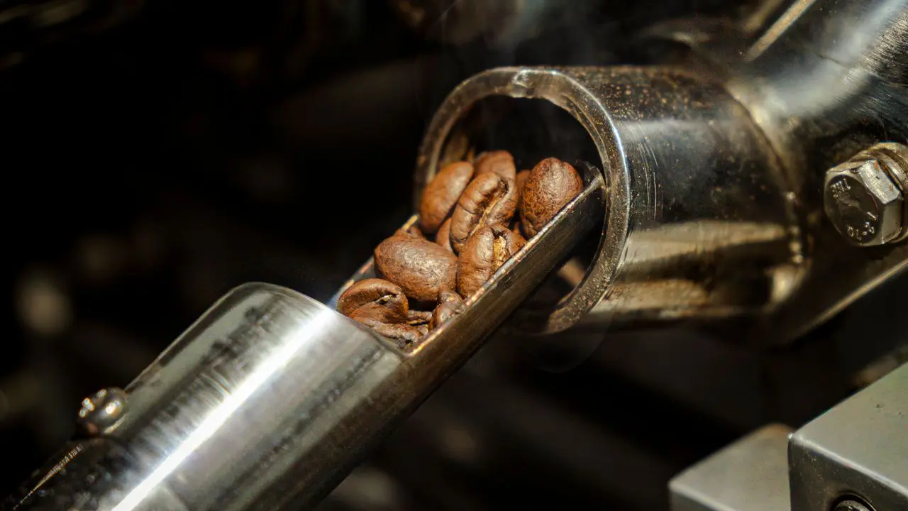 Arabica coffee beans released from a roasting drum at Bali Origins, highlighting controlled roasting and consistent quality standards.