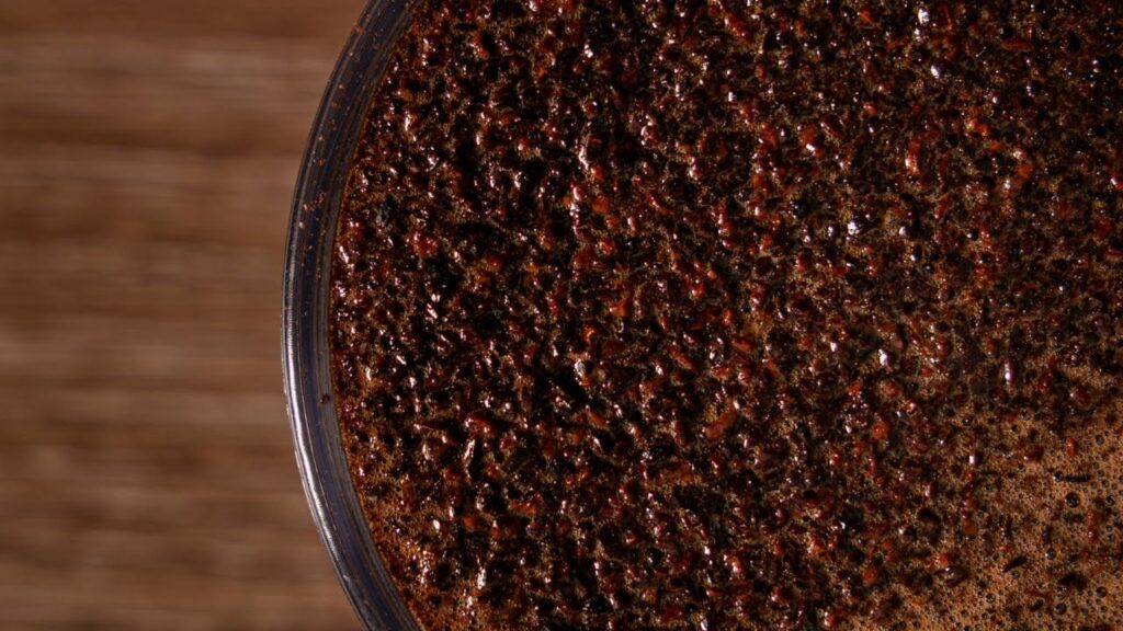 Close-up of freshly brewed Robusta coffee at Bali Origins, highlighting its dense body, dark crema, and strong extraction profile.